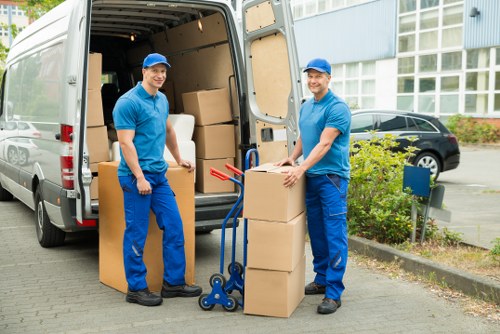 Professional movers carrying furniture through an apartment building entrance